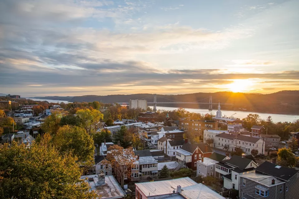 Aerial view of small town in Hudson Valley, New York State with river at sunset.
